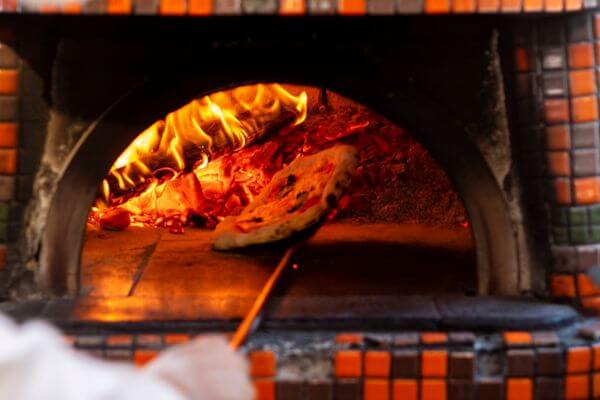 four à pizza à bois en cuisine professionnelle